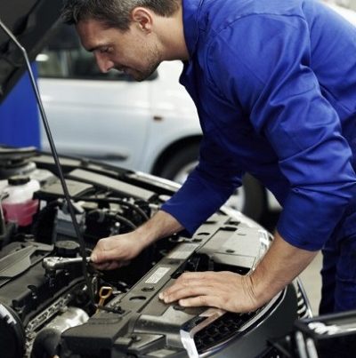 mechanic looking inside a car