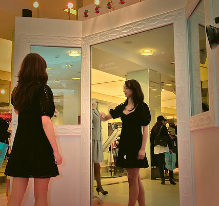 woman looking in a big mirror
