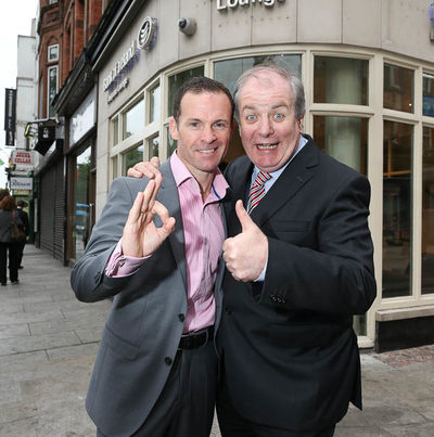 2 men posing in front of enterprise lounge building
