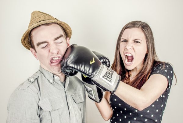 woman punching a man wearing a boxing glove