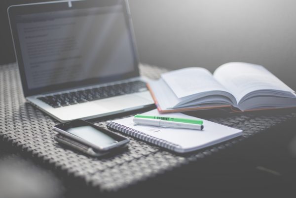 laptop, paper, pens and phone