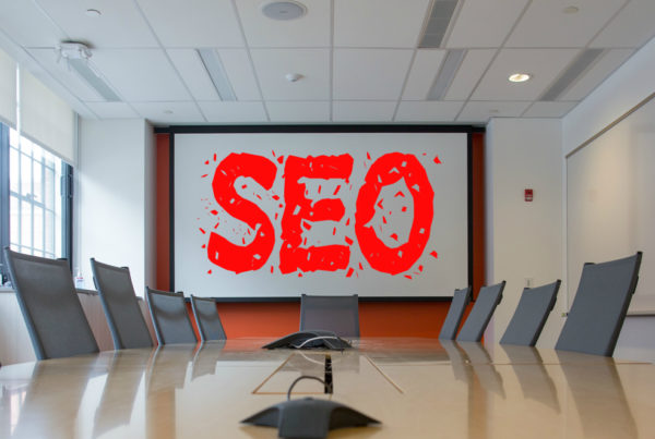 office with a centre table, chairs and 'seo' on a digital whiteboard