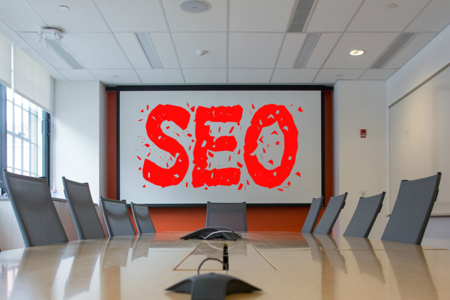 office with a centre table, chairs and 'seo' on a digital whiteboard