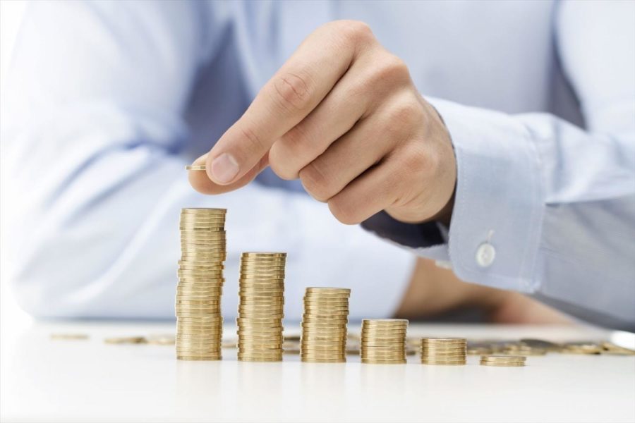 man stacking up coins into piles