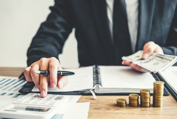 man counting money and working on a calculator