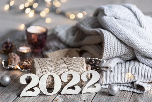 wooden '2022' sign on a wooden table with a blanket and candles