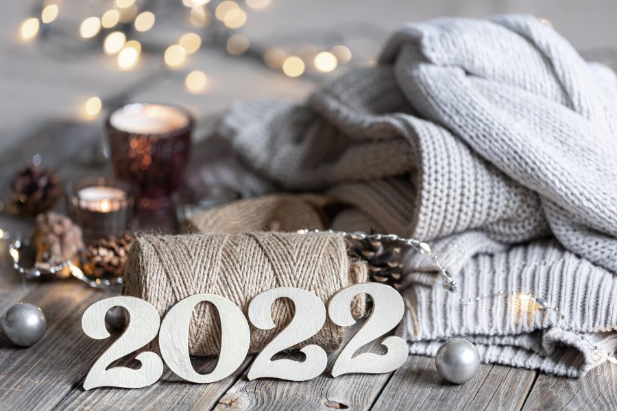 wooden '2022' sign on a wooden table with a blanket and candles