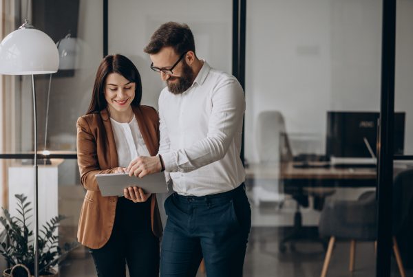 female and male in an office looking at documents